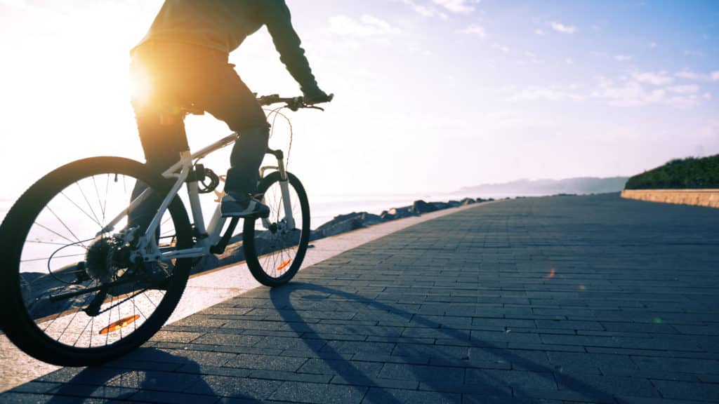 Fietsende persoon met zonsopgang op achtergrond
