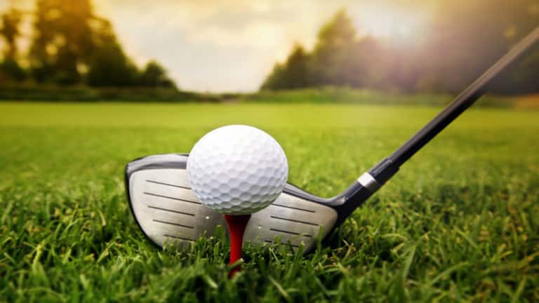 dichte omhooggaand van golfclub en bal op golfcursus