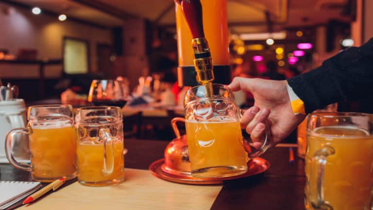 Persoon schenkt bier in glas uit tapkranen